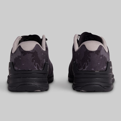 Black and grey camouflage athletic shoes on a gray background