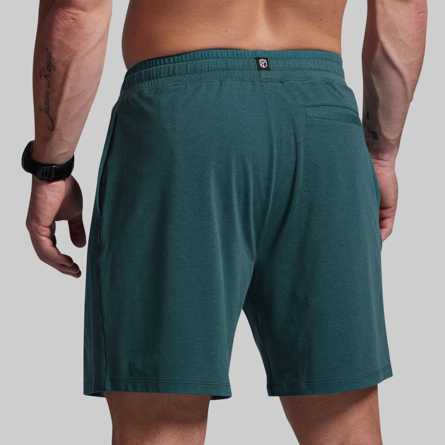 Teal shorts worn by a person on a plain background