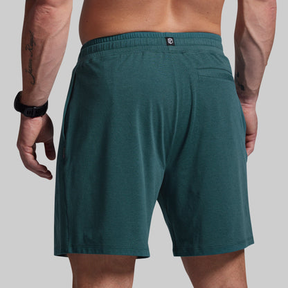 Teal shorts worn by a person on a plain background