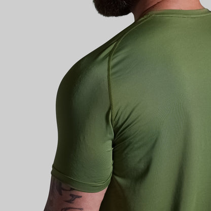 Person wearing a green athletic shirt on a plain background