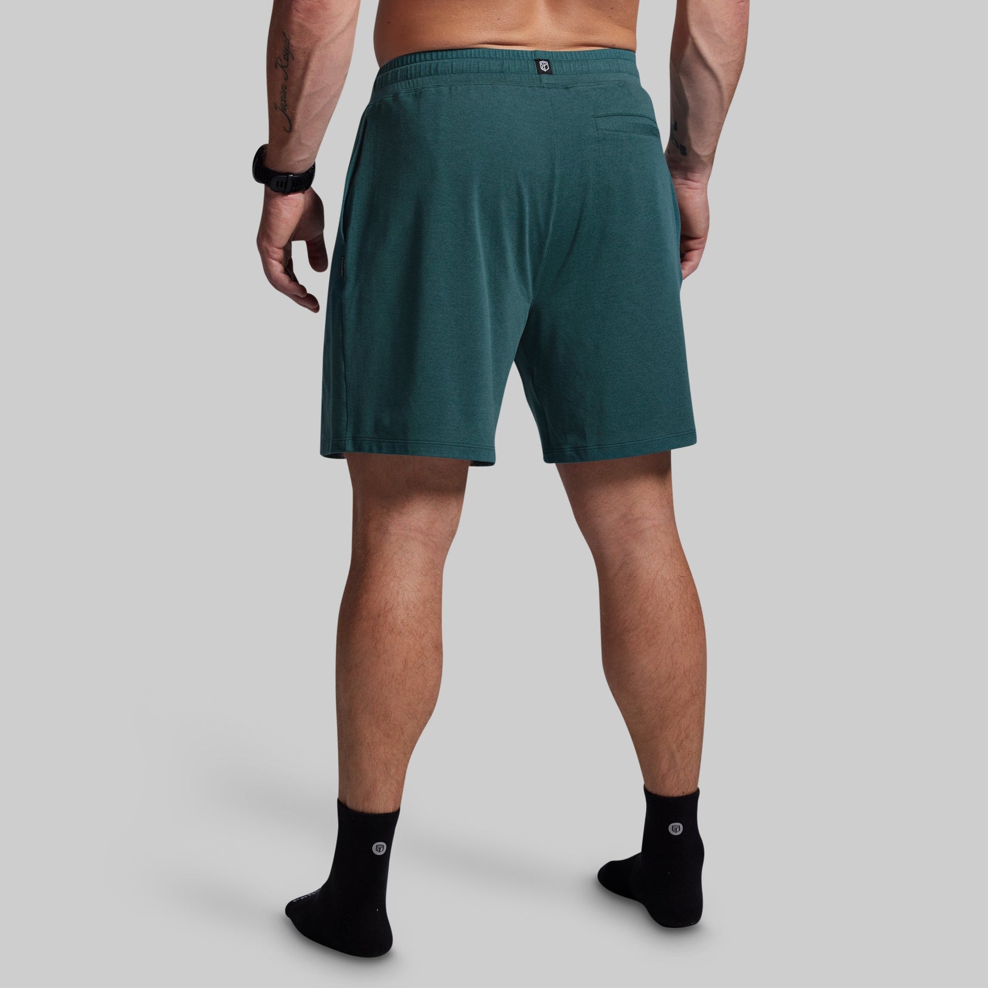 Person wearing teal shorts on a gray background
