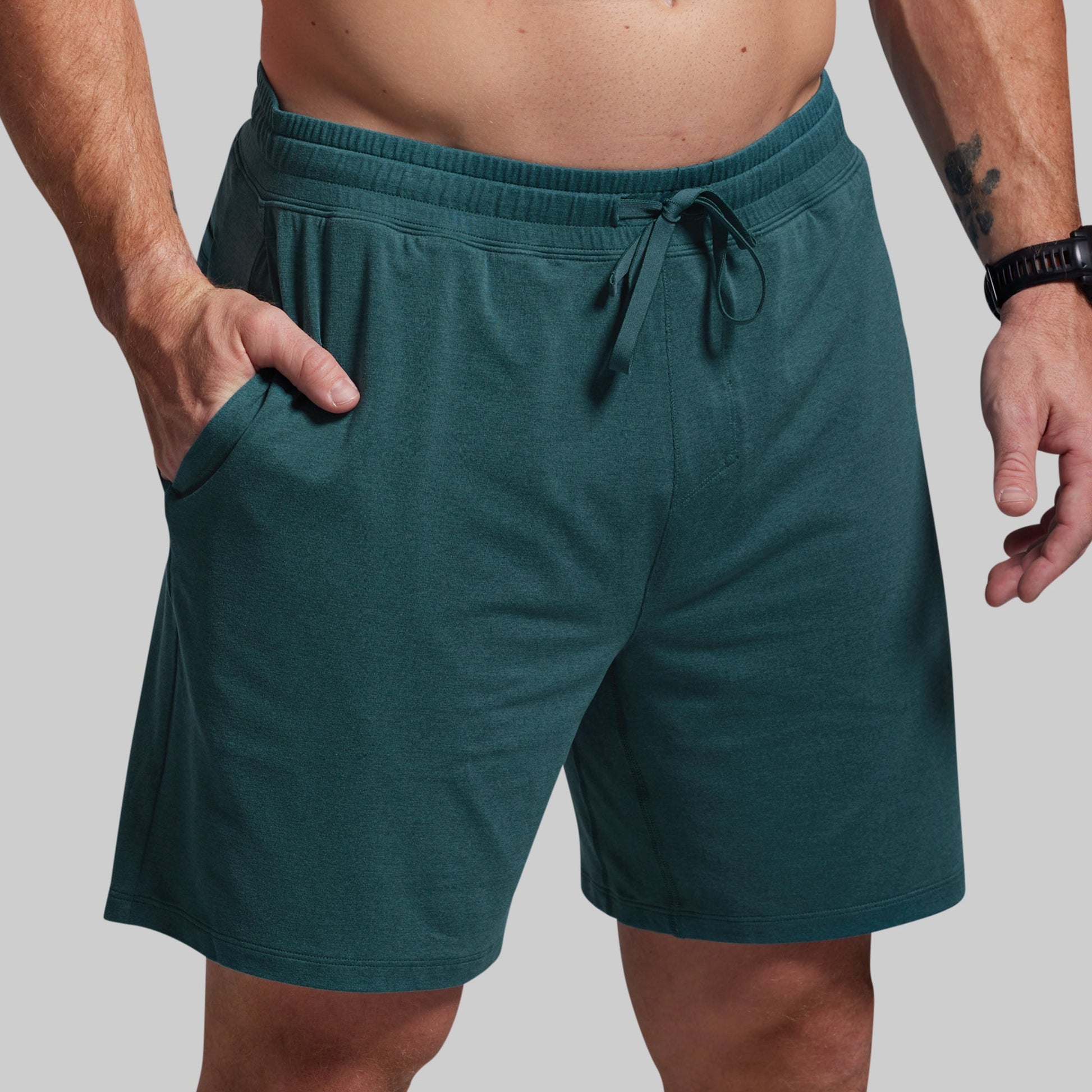 Teal shorts with a drawstring on a gray background