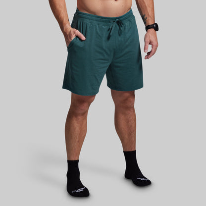 Person wearing teal shorts on a plain background