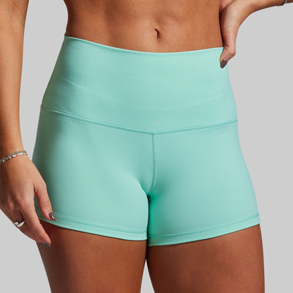 Teal athletic shorts worn by a person on a plain background