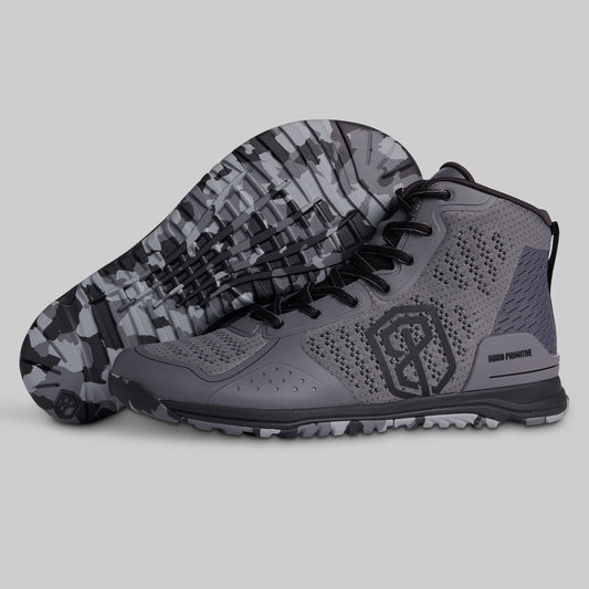 Gray athletic shoes with camouflage sole on a light gray background