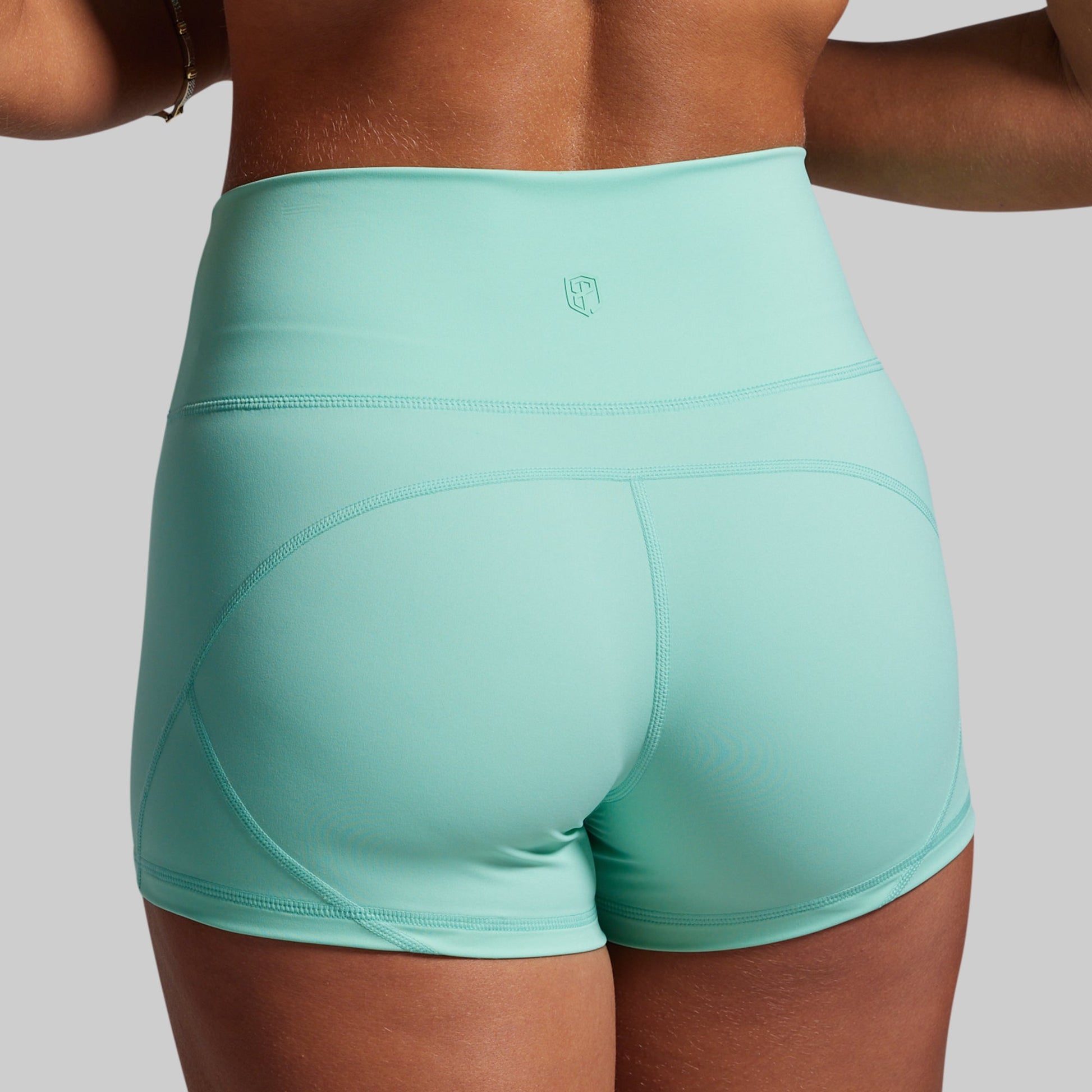 Turquoise athletic shorts worn by a person on a plain background