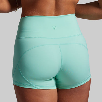 Turquoise athletic shorts worn by a person on a plain background