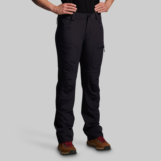 Person wearing black pants on a gray background