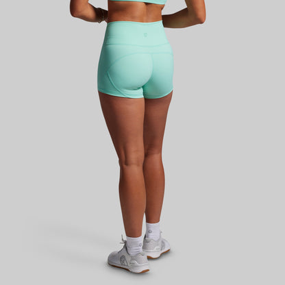 Person wearing teal shorts on a plain background