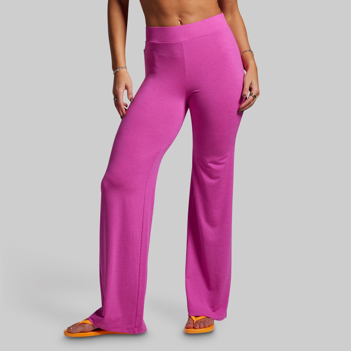 Person wearing bright pink pants on a gray background