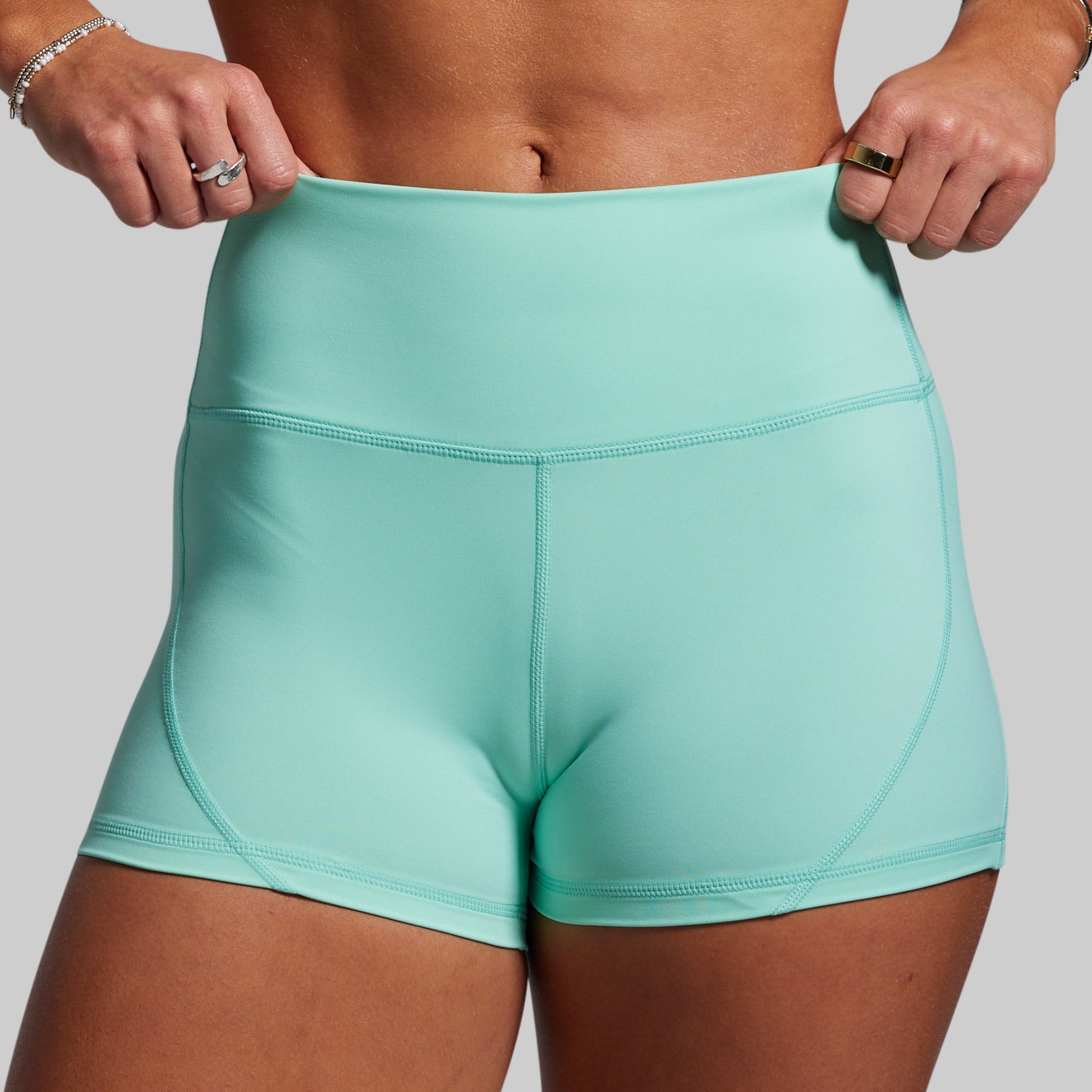 Teal athletic shorts worn by a person on a plain background
