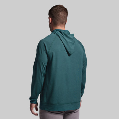 Man wearing a teal hoodie from behind on a gray background