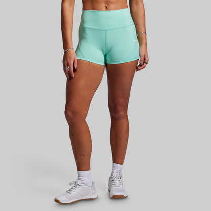 Person wearing teal athletic shorts on a gray background