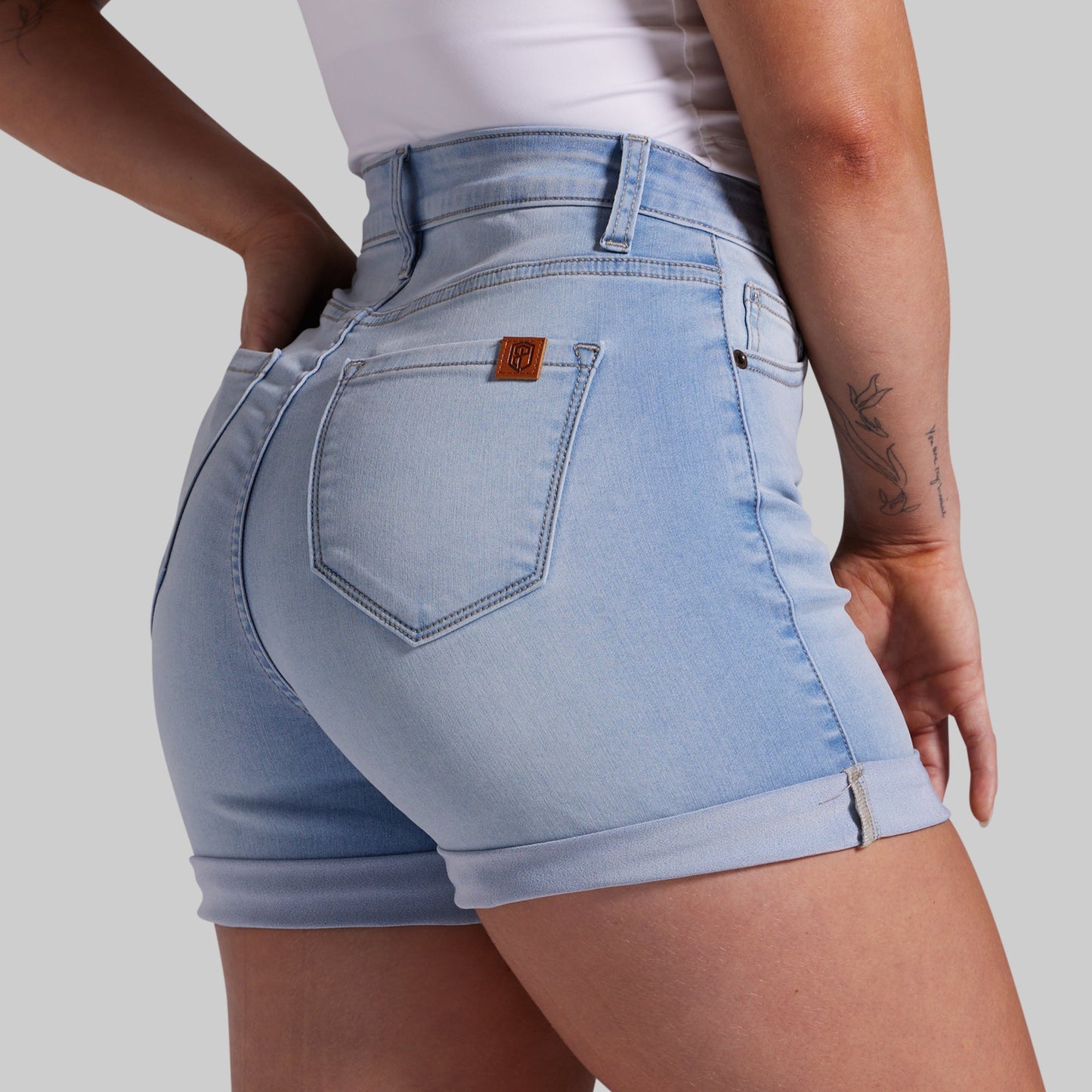 Light blue denim shorts worn by a person on a plain background