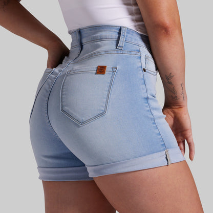 Light blue denim shorts worn by a person on a plain background