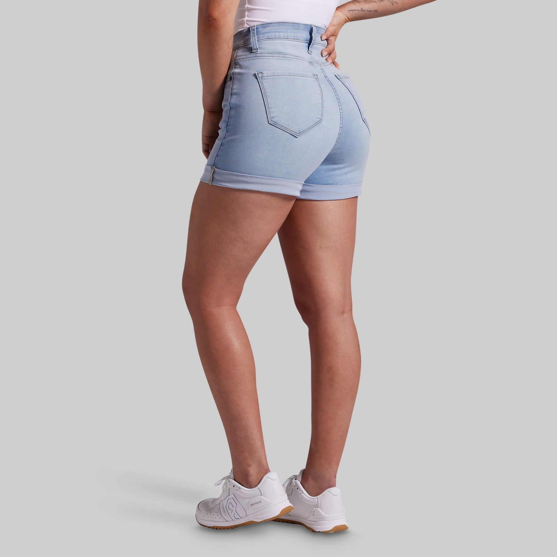 Light blue denim shorts worn by a person on a gray background