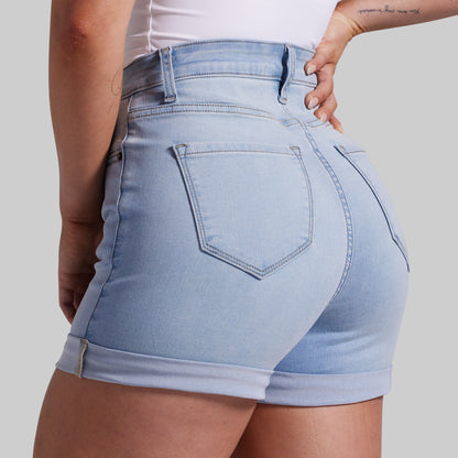 Light blue denim shorts worn by a person on a plain background