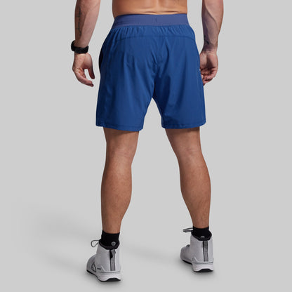 Person wearing blue athletic shorts on a gray background