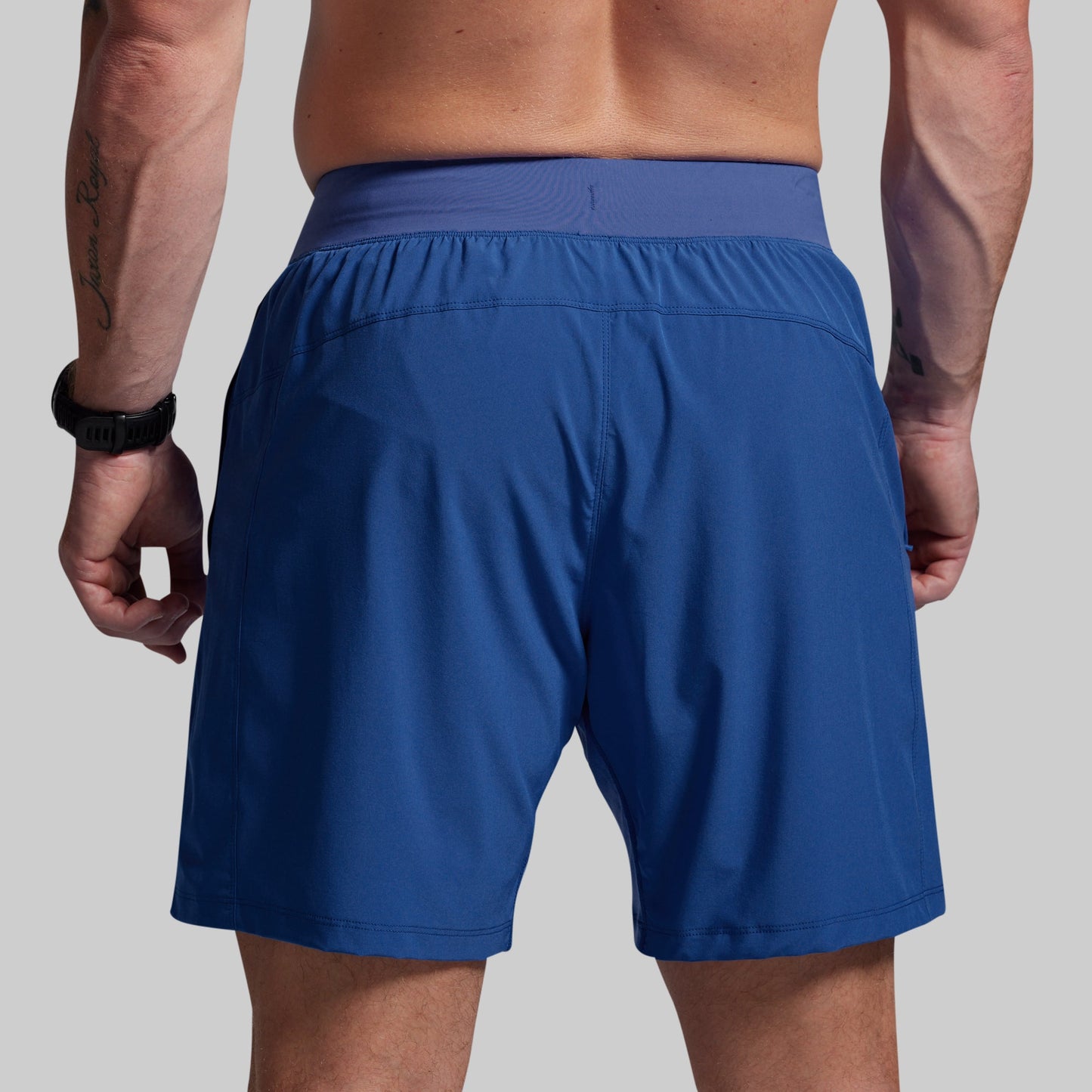 Blue athletic shorts worn by a person on a gray background