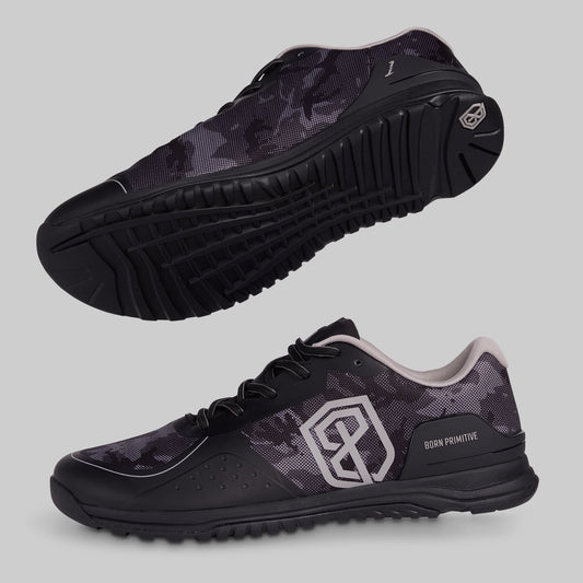 Black and grey camouflage athletic shoes with a visible brand logo on a gray background