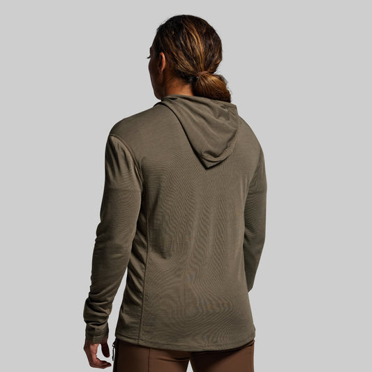 Person wearing a green hoodie on a plain background