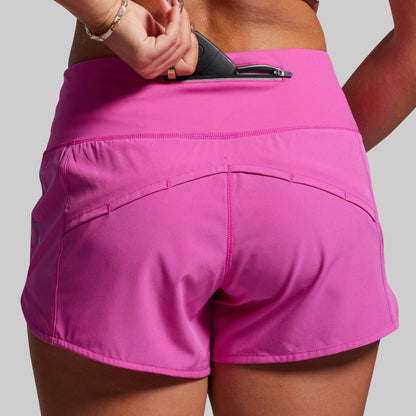 Pink athletic shorts with a zipper pocket on a plain background