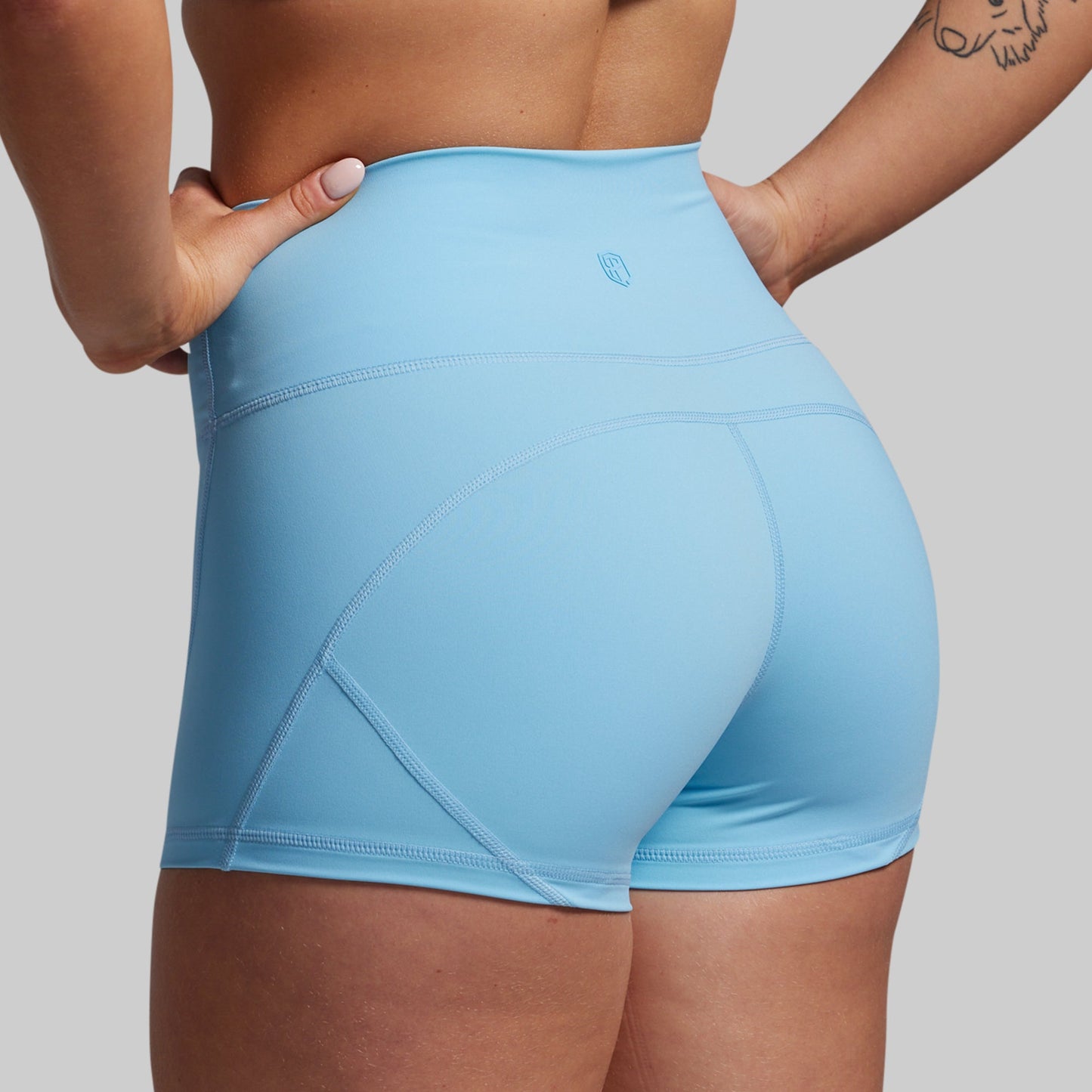 Light blue athletic shorts worn by a person on a gray background