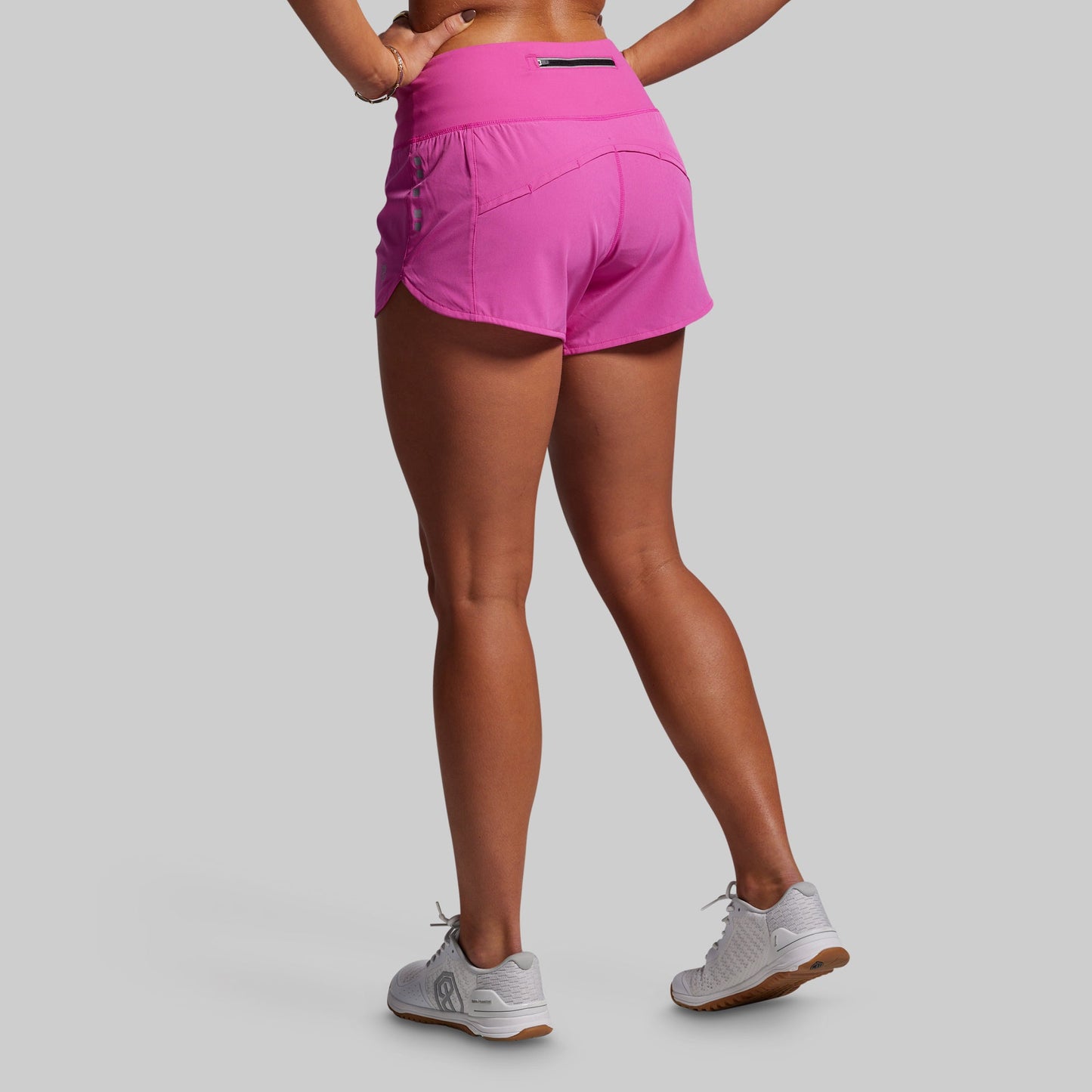 Person wearing pink athletic shorts on a gray background