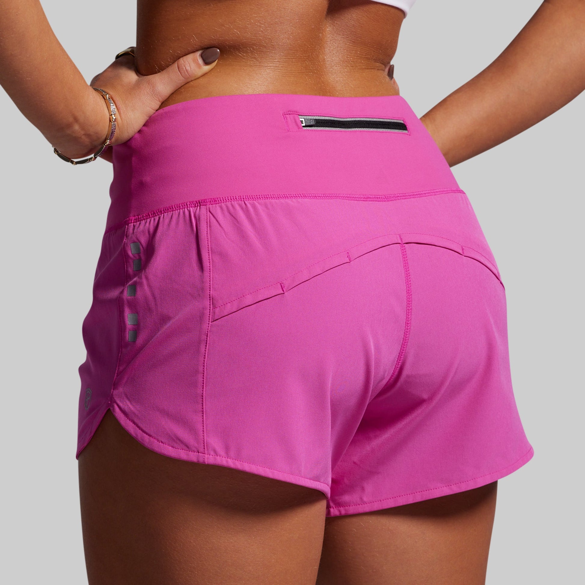 Person wearing bright pink athletic shorts on a plain background