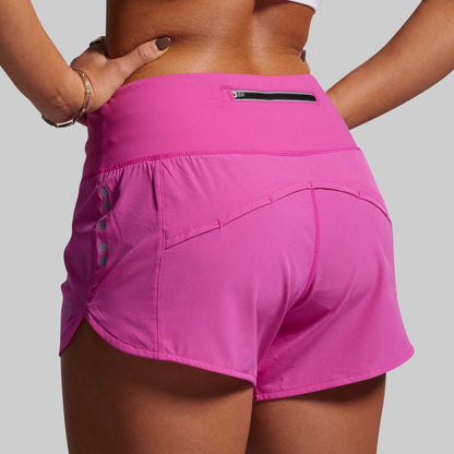 Person wearing bright pink athletic shorts on a plain background