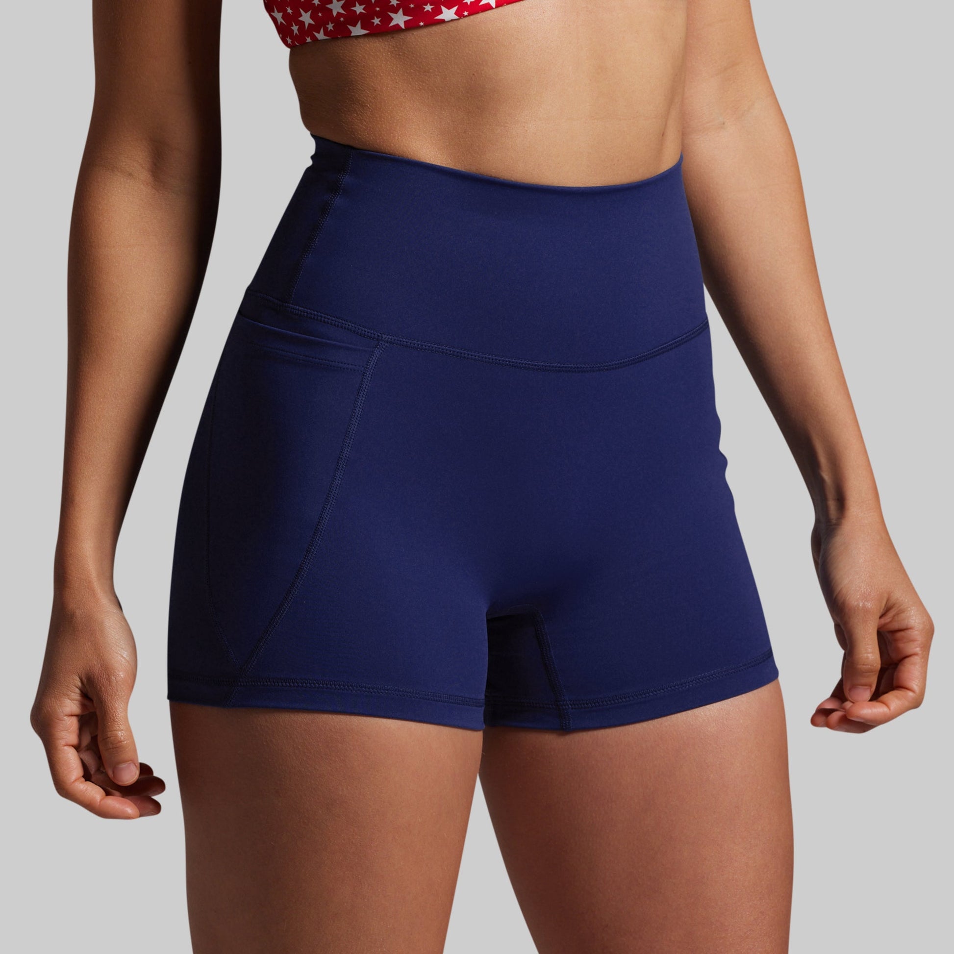Person wearing blue athletic shorts on a plain background