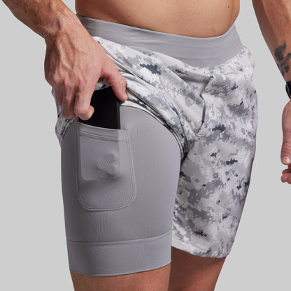 Gray and white camouflage athletic shorts with a pocket on a gray background