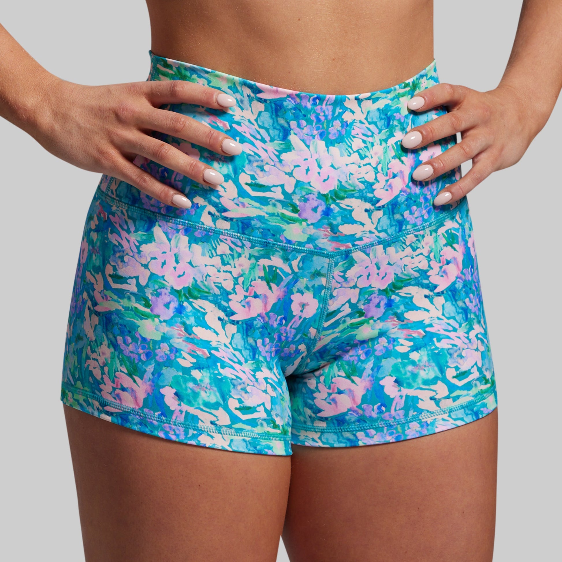 Colorful floral shorts worn by a person on a plain background