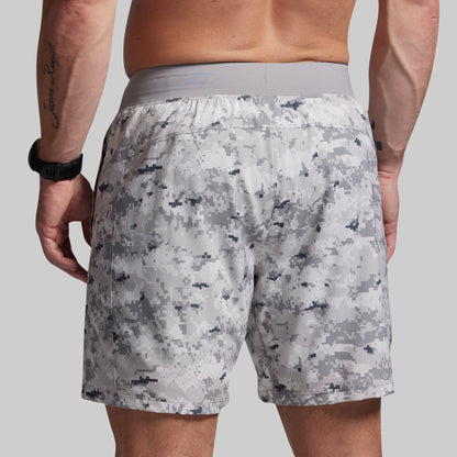 Person wearing camouflage shorts on a plain background