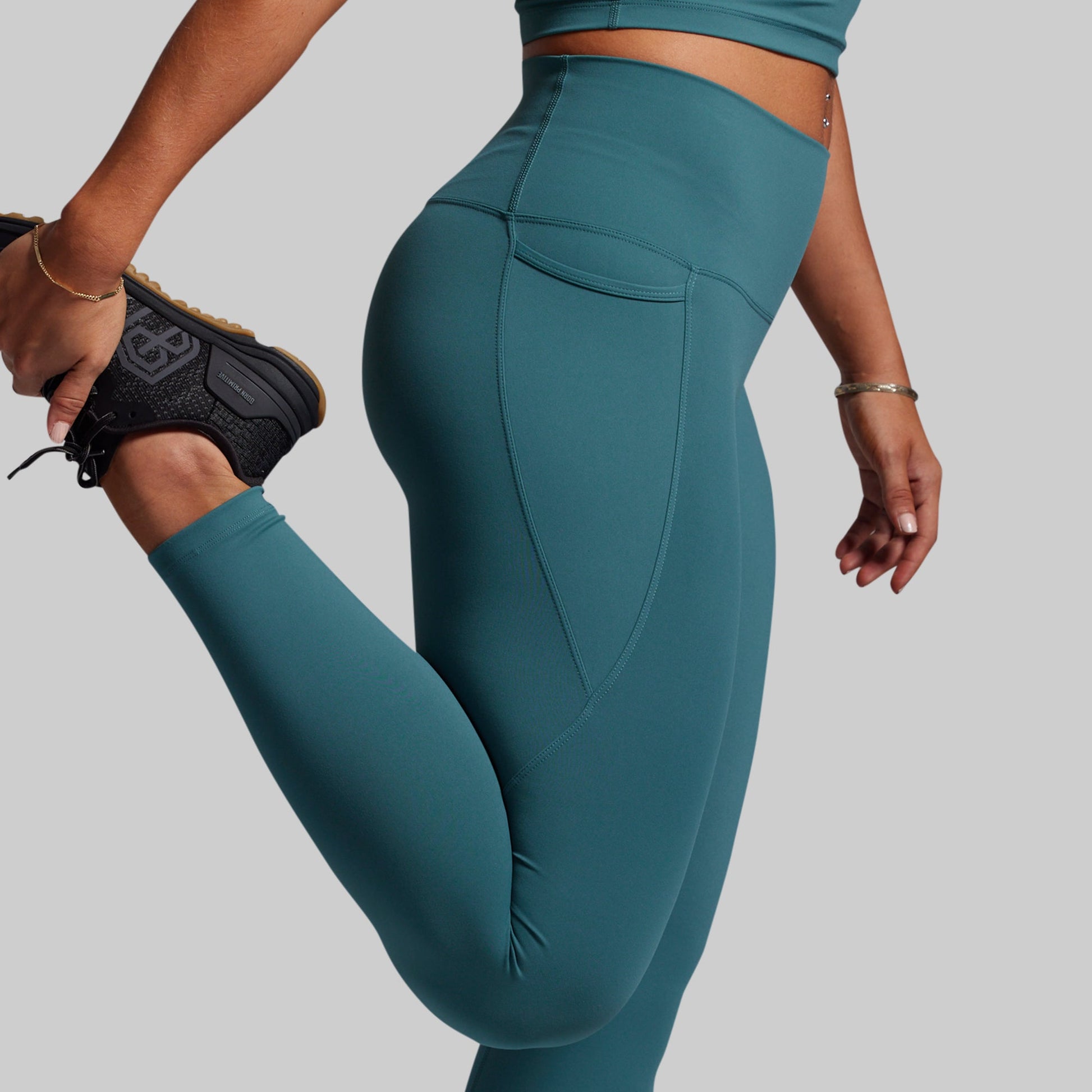Teal leggings worn by a person on a plain background
