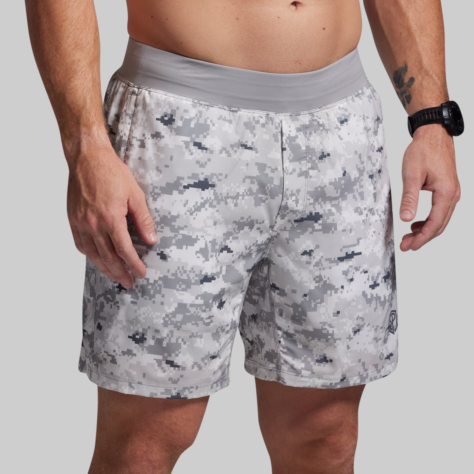 Person wearing camouflage shorts on a plain background