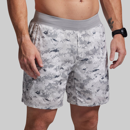Person wearing camouflage shorts on a plain background