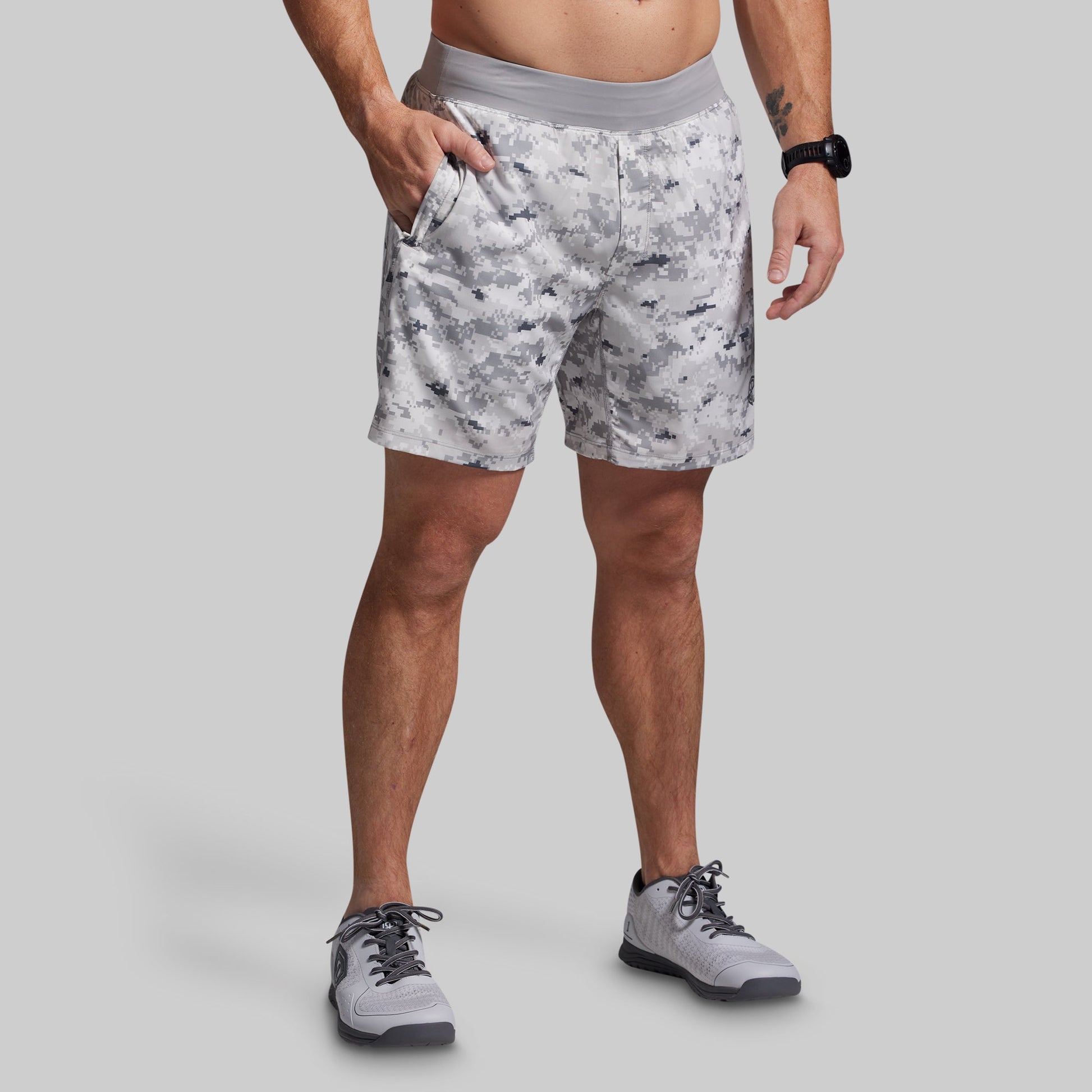 Person wearing camouflage shorts on a gray background