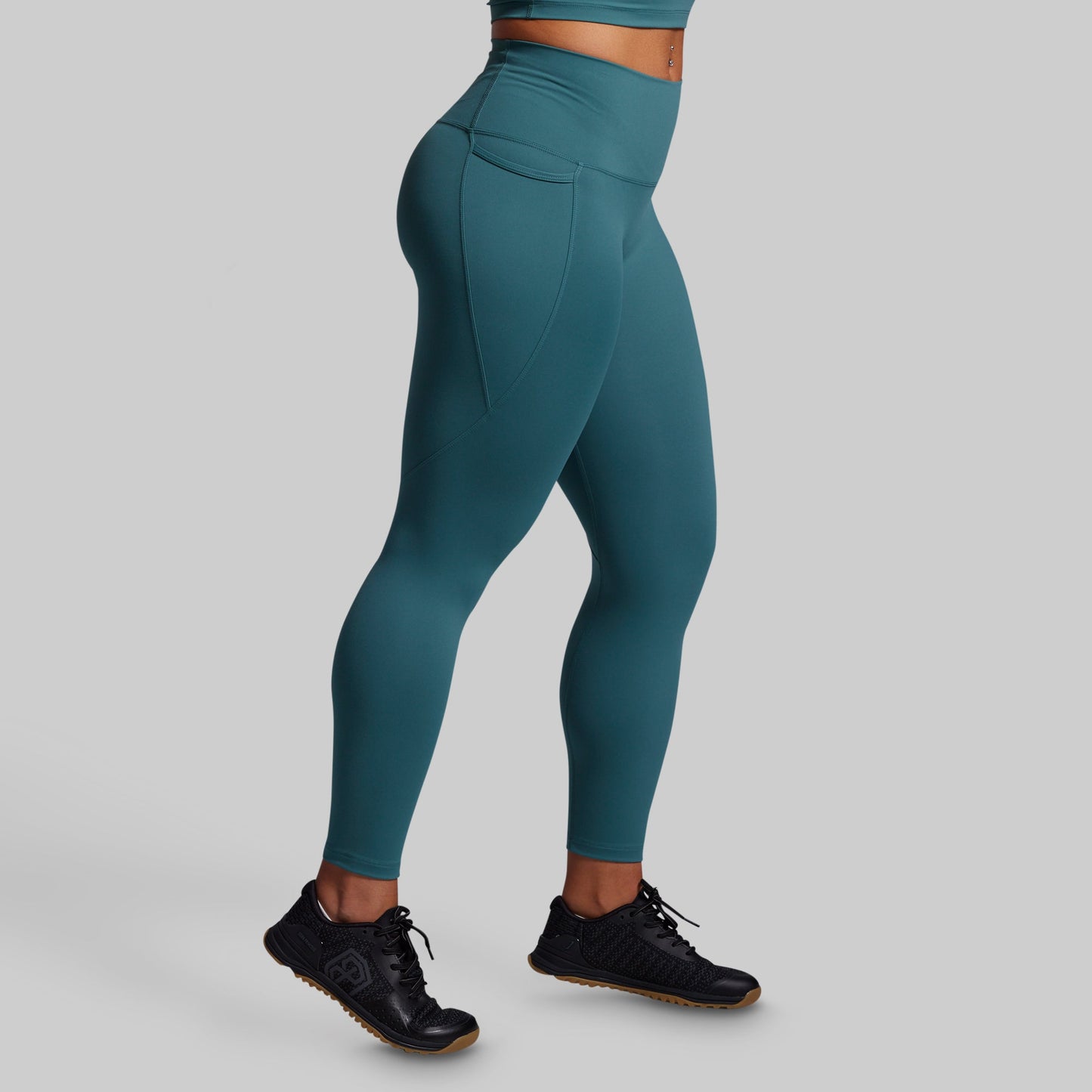 Teal leggings worn by a person on a gray background