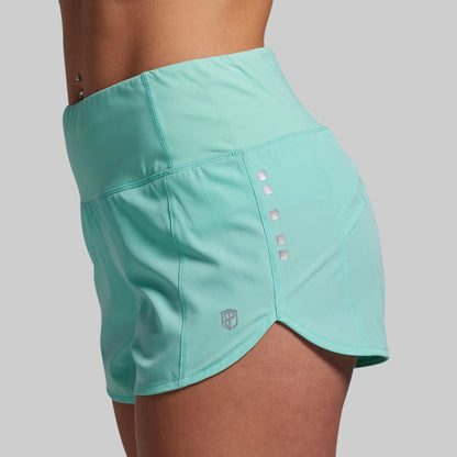 Turquoise athletic shorts on a plain background