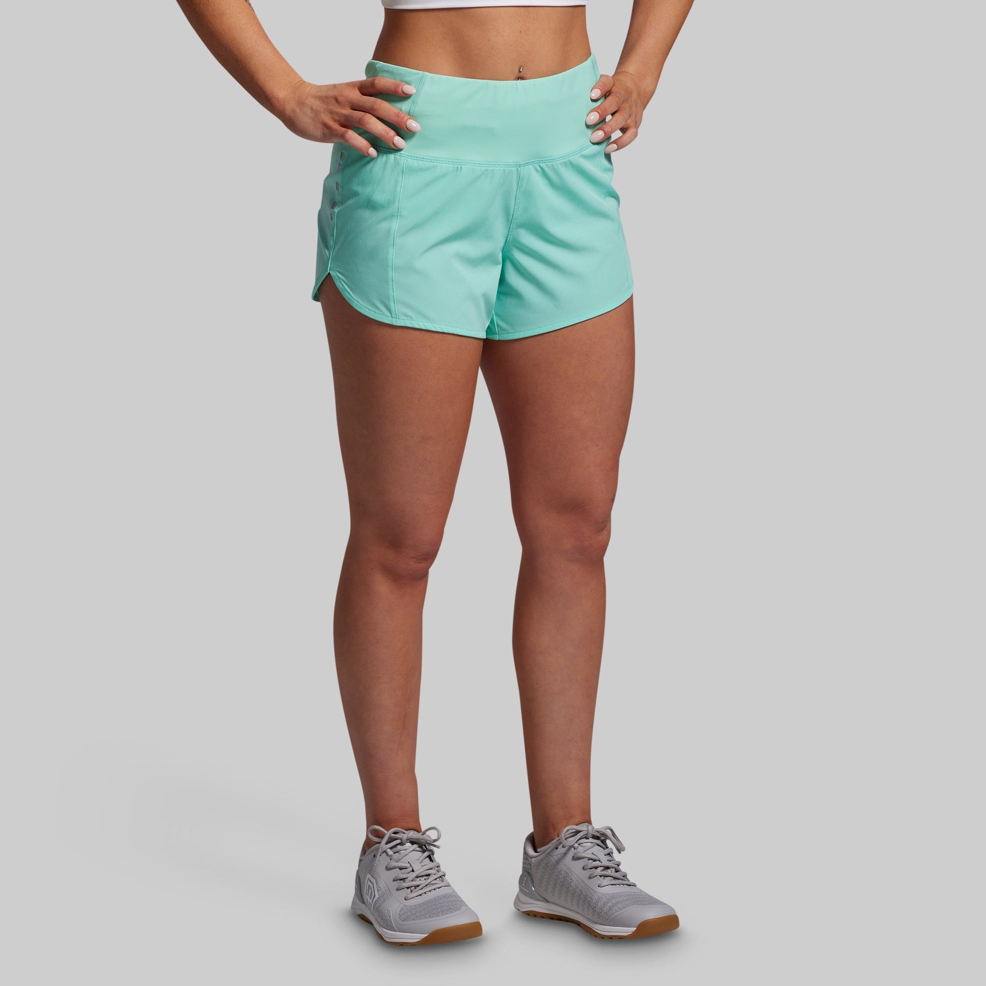 Person wearing light blue athletic shorts on a gray background