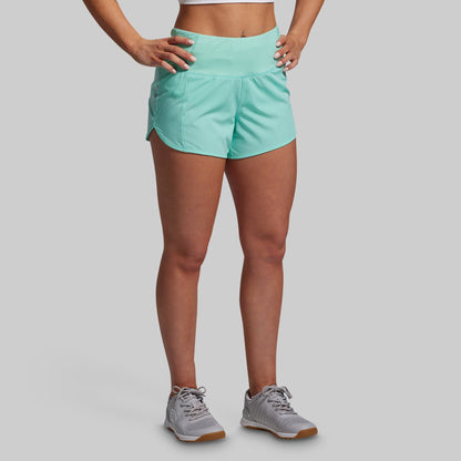 Person wearing light blue athletic shorts on a gray background