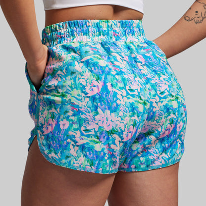 Colorful floral shorts worn by a person on a plain background