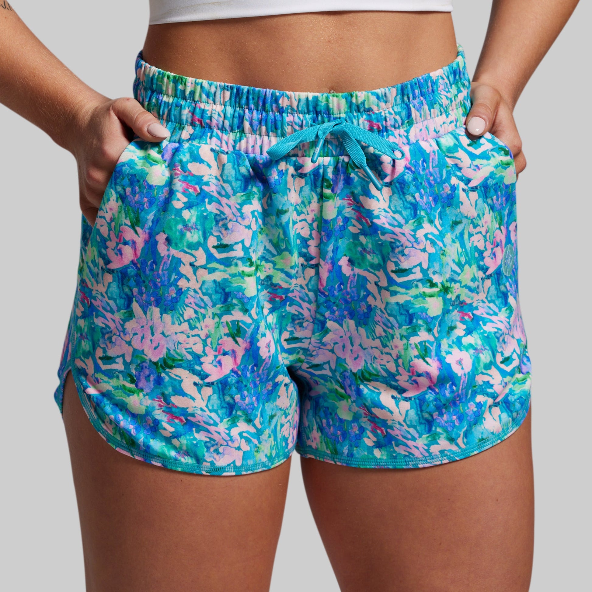 Colorful floral shorts worn by a person on a plain background
