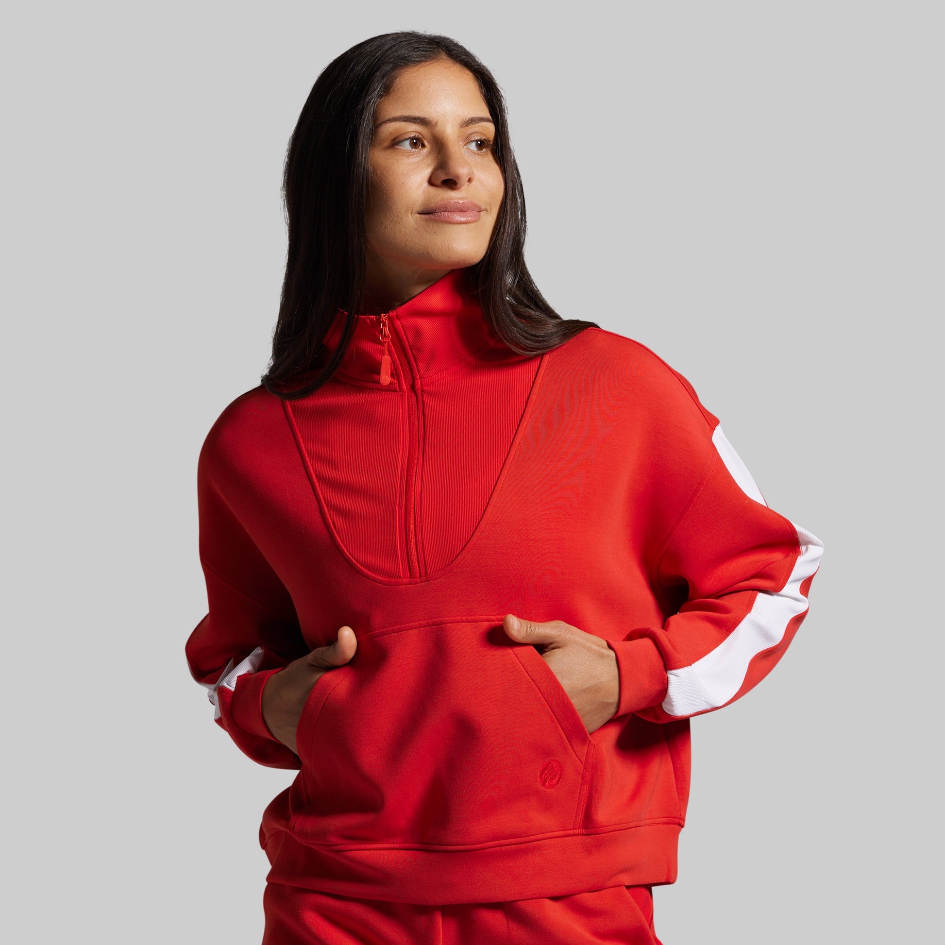 Person wearing a red sweater with white stripes on a gray background