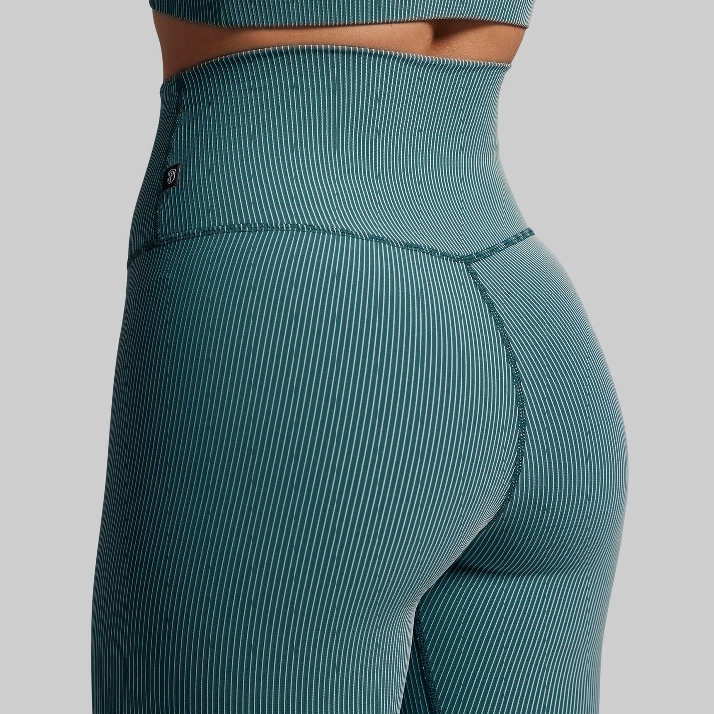 Teal ribbed leggings on a gray background