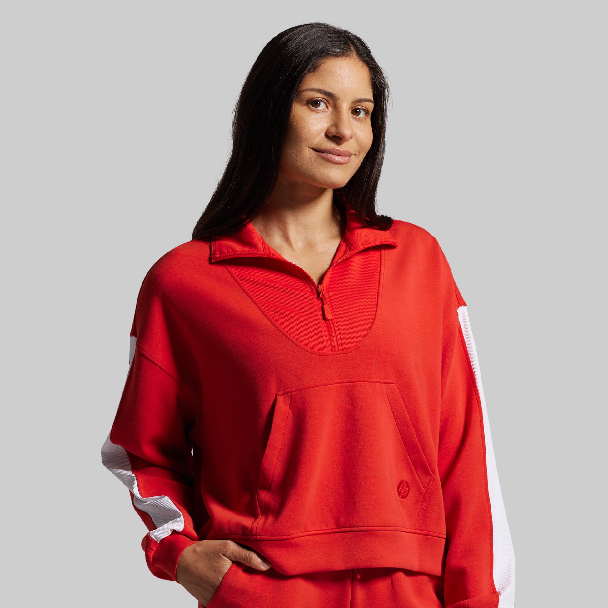 Woman wearing a red outfit with white accents on a gray background