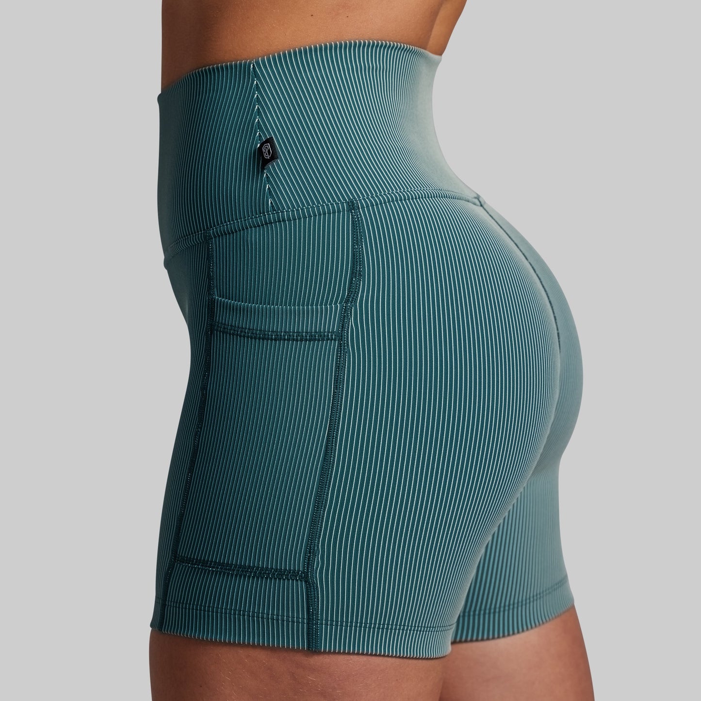 Teal athletic shorts on a gray background