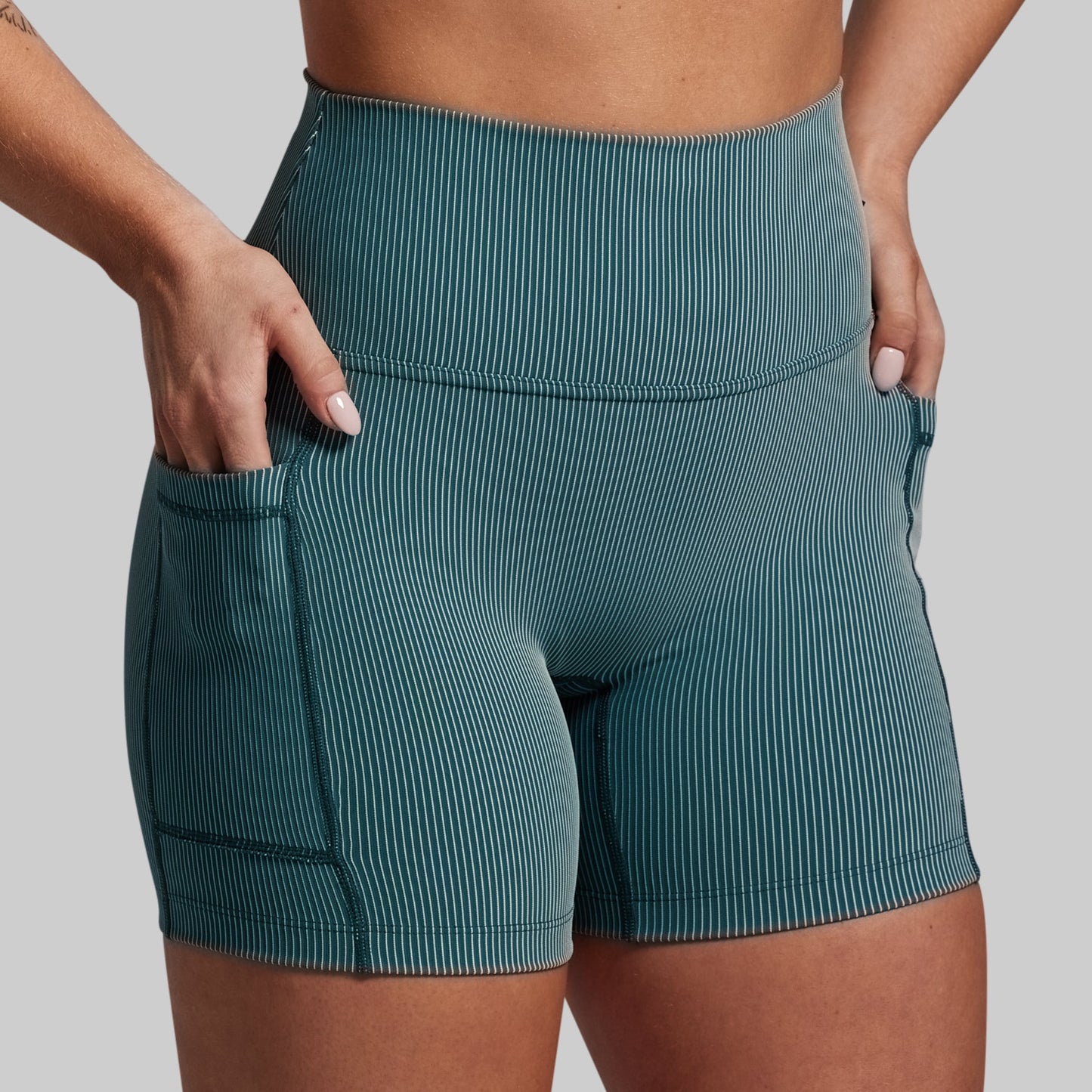 Teal ribbed shorts worn by a person on a gray background
