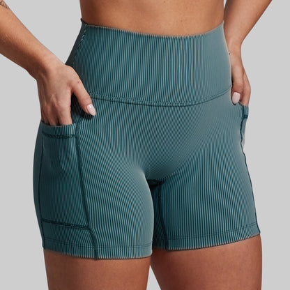 Teal ribbed shorts worn by a person on a gray background